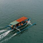 anmol A colorful traditional boat cruises on the serene waters of Nusa Tenggara Barat, Indonesia.