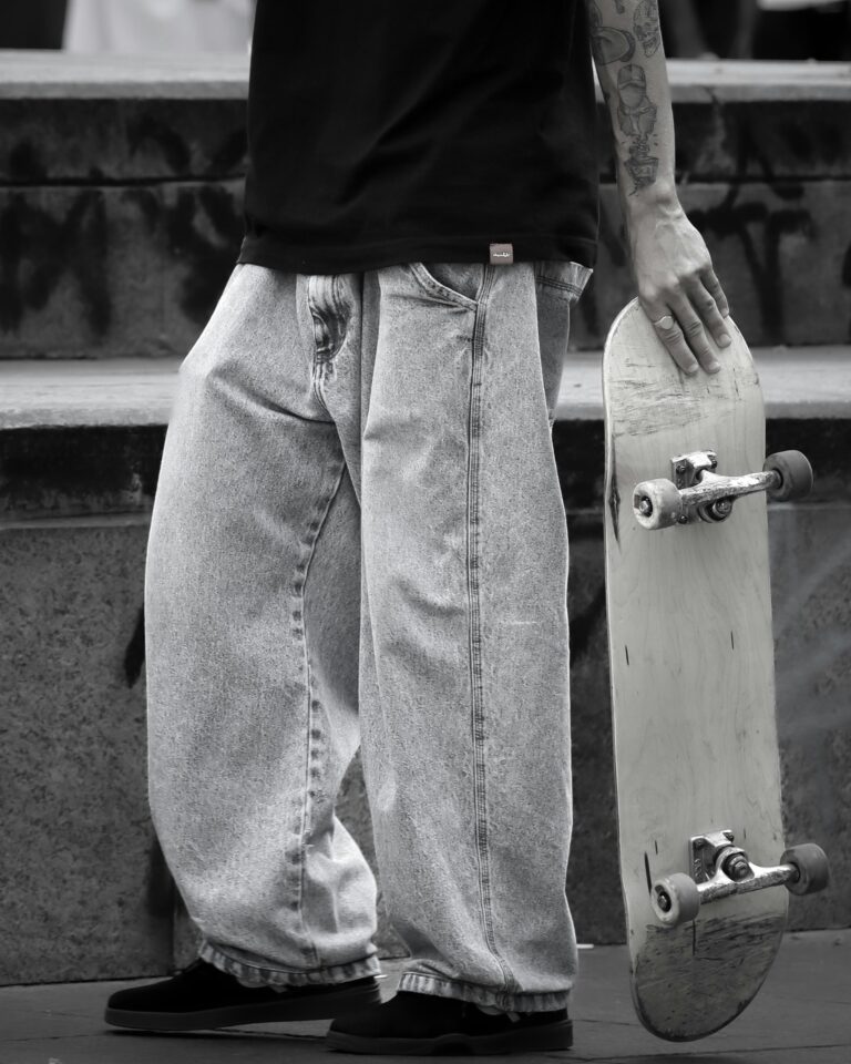 Stylish young skater holding skateboard, showcasing urban street fashion.