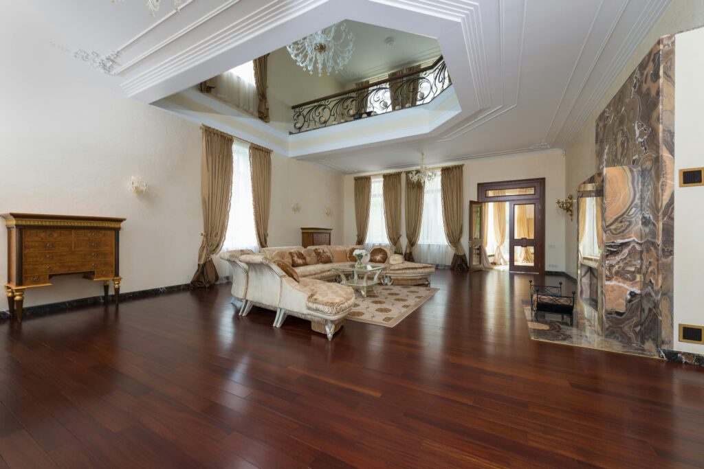 Interior design Creative design of spacious room interior with sofa and table on carpet under chandelier in light house with wooden floor
